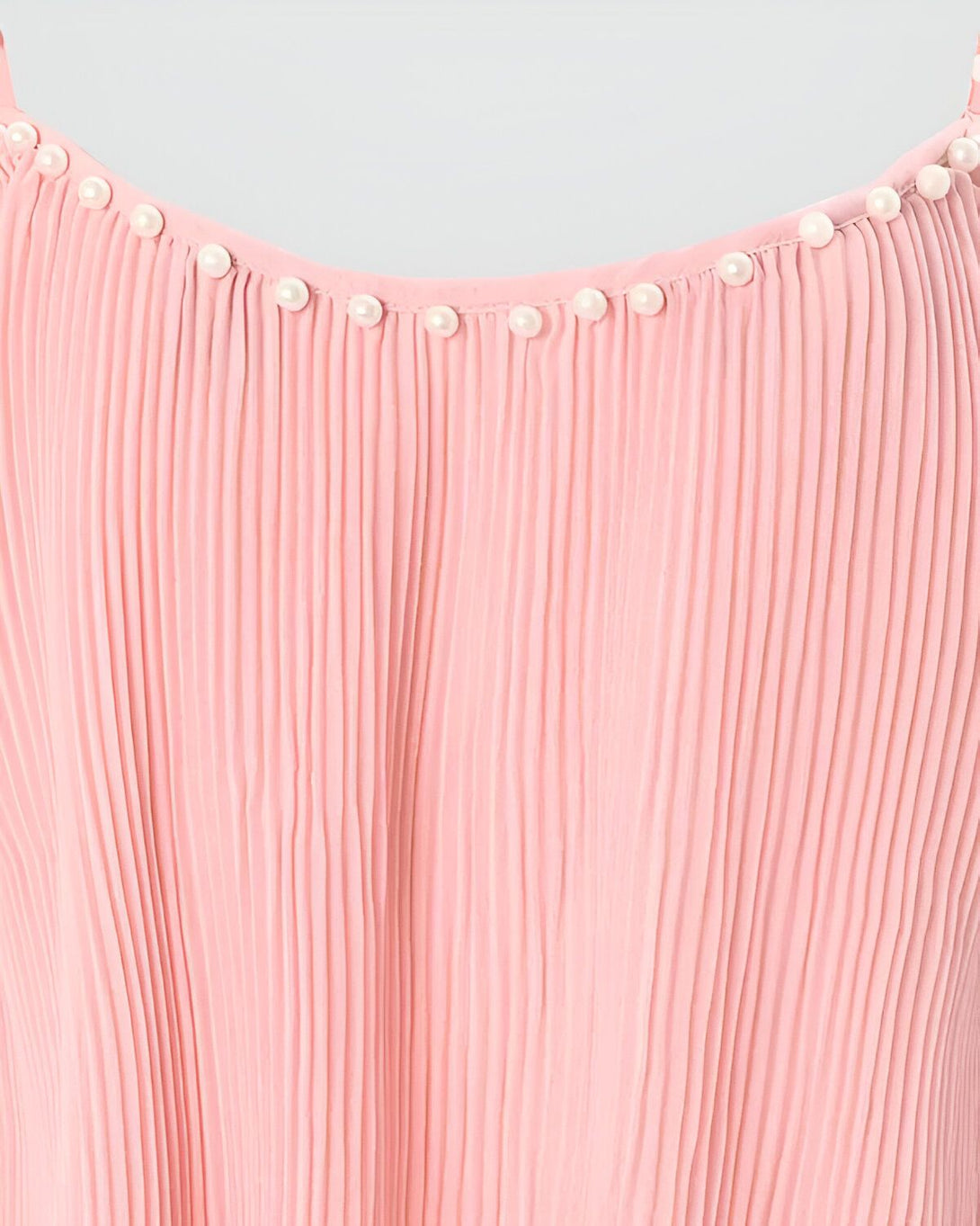 Une image d'une robe rose plissée avec des boutons blancs nacrés.