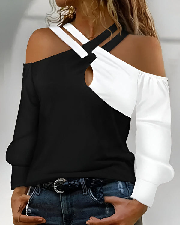 Une femme porte un haut noir et blanc à épaules dénudées. Le haut est croisé sur le devant et a un trou au niveau du décolleté. La femme porte également un jean bleu et une ceinture marron.
