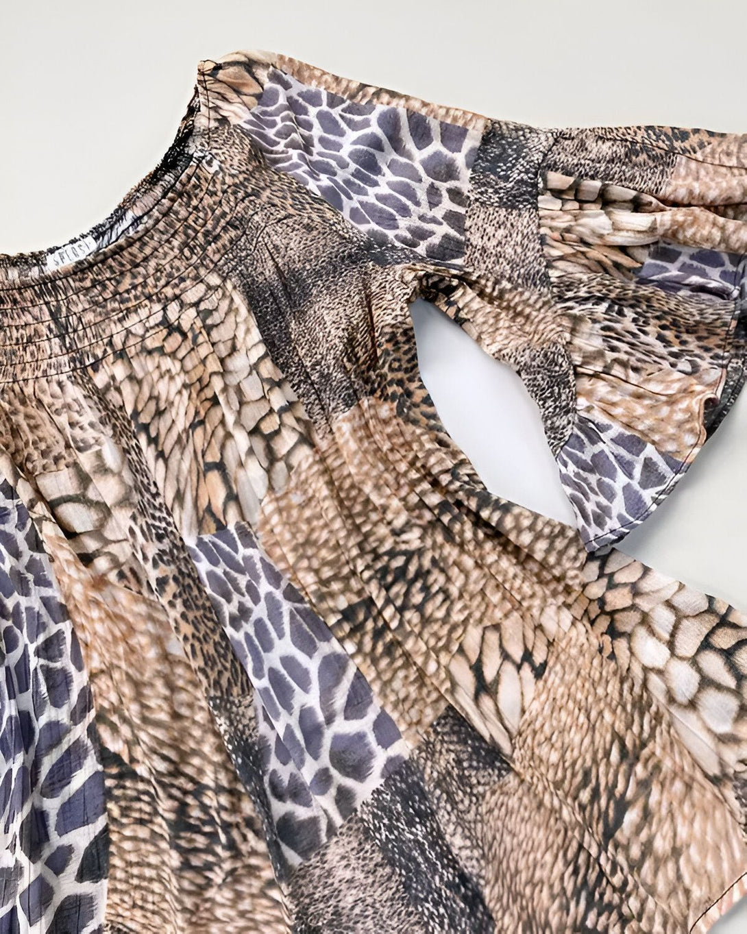 Chemisier marron et noir à motif animal avec des manches bouffantes et un col montant froncé.