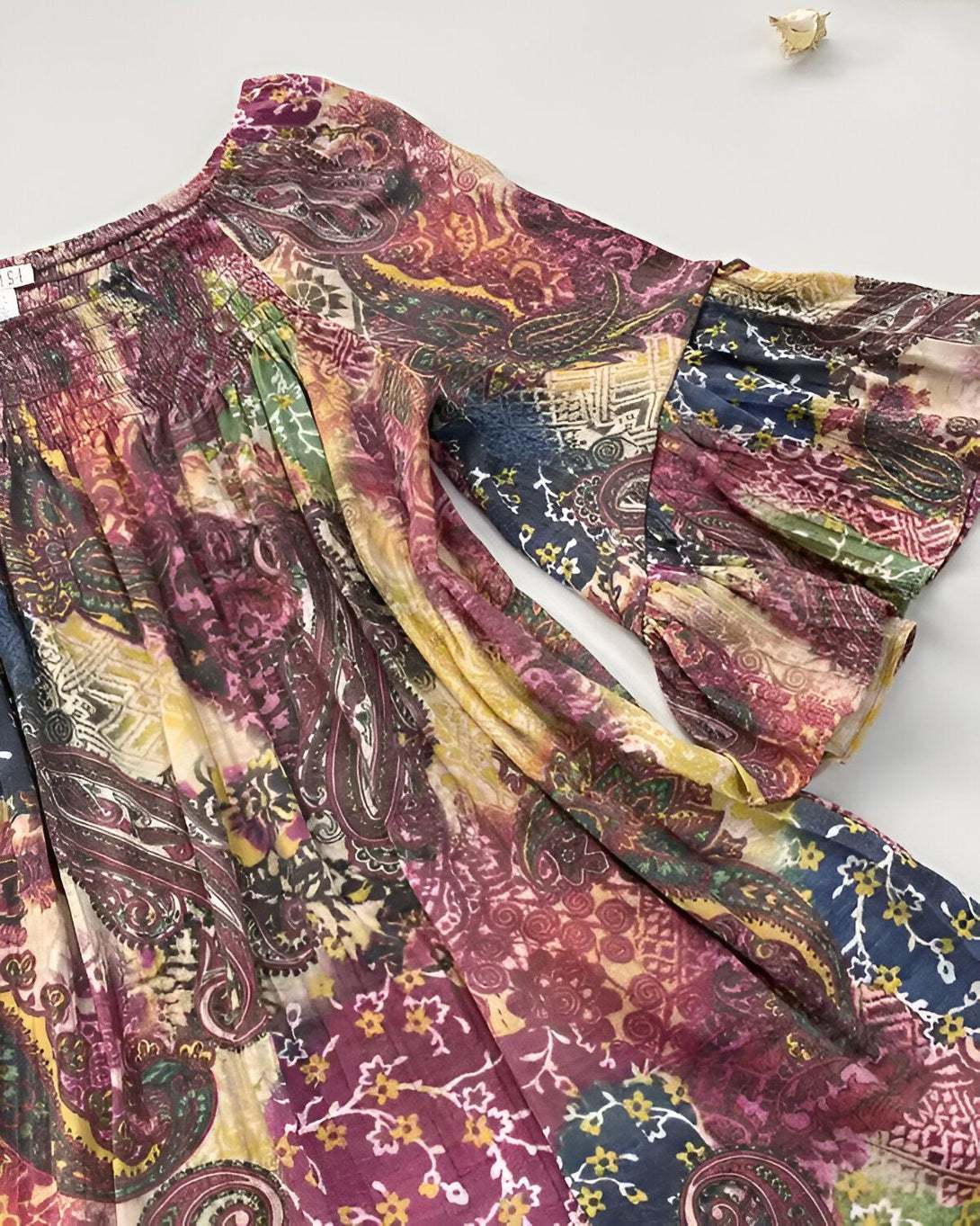 Une image d'une robe colorée avec des motifs cachemire et des manches bouffantes.