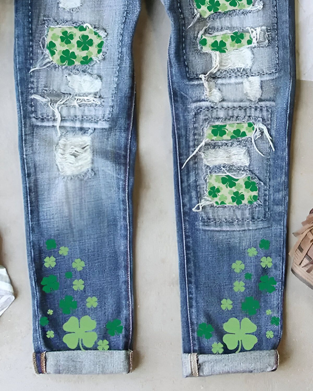 Une image de jeans déchirés avec des trèfles verts.