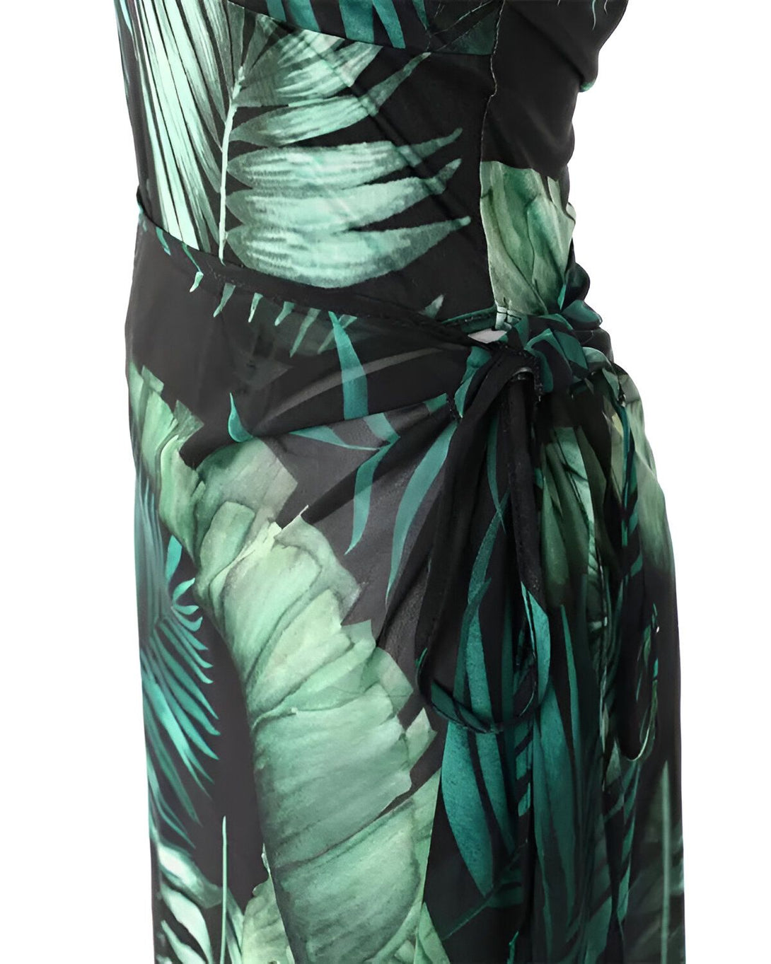 Une femme porte une robe portefeuille longue verte à motifs de feuilles tropicales. La robe est nouée sur le côté.