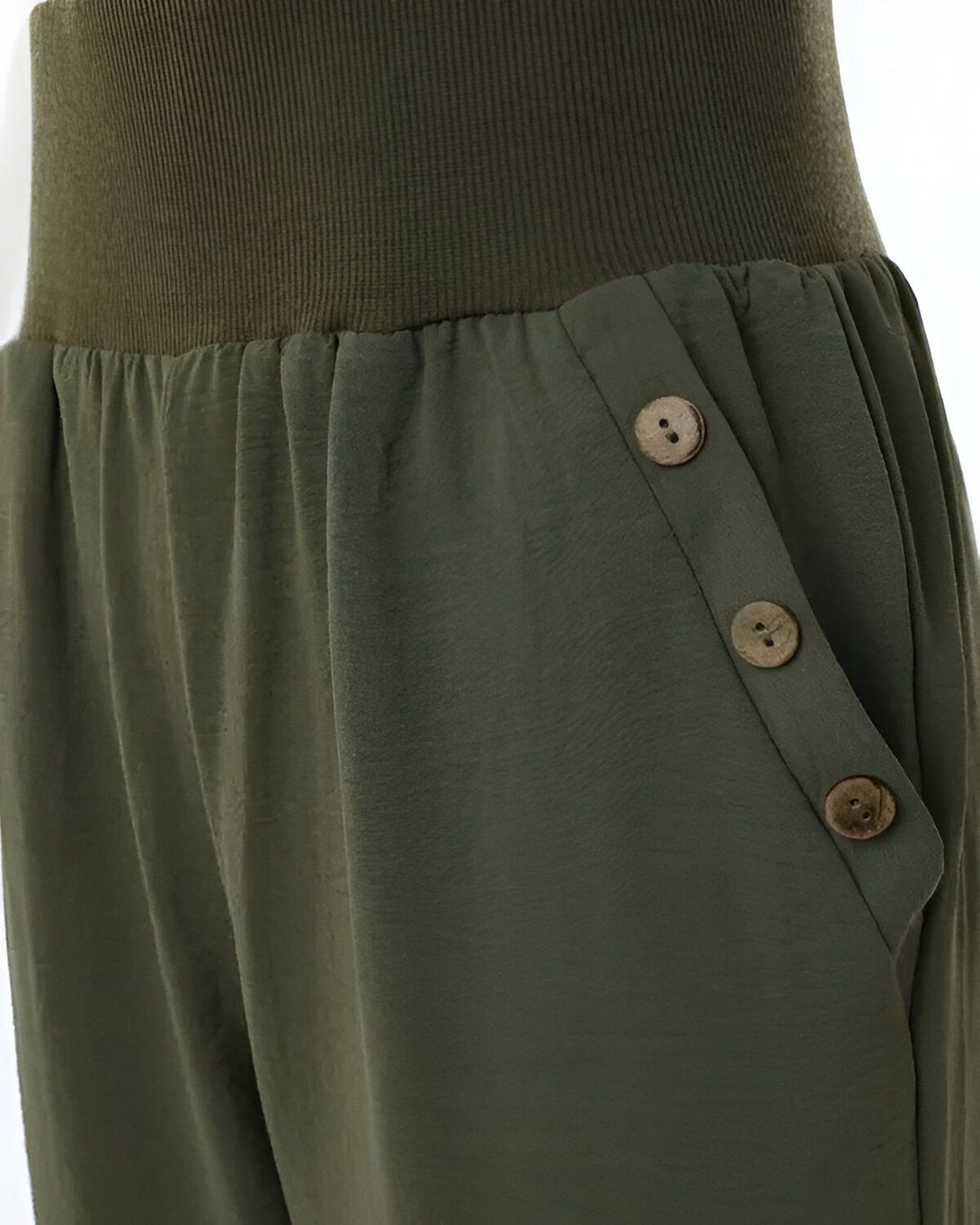 Une image d'un pantalon ample vert kaki taille haute avec des boutons en bois sur le côté.