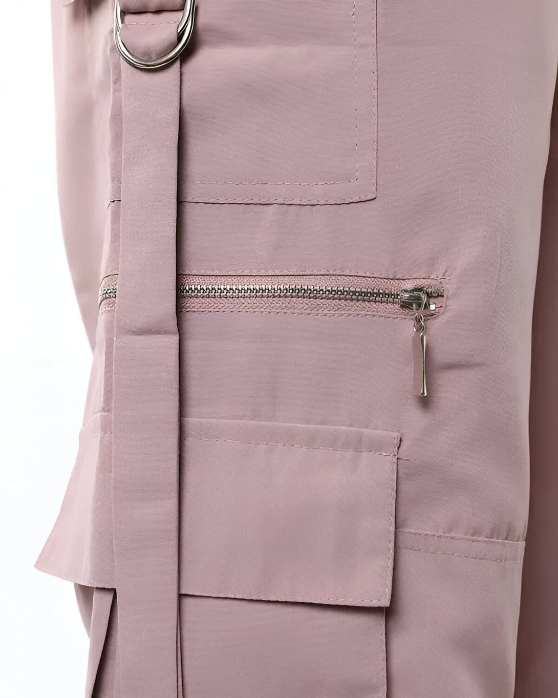 Le pantalon cargo rose a des poches zippées et une ceinture à boucle.