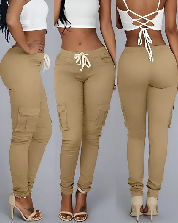 Une femme porte un pantalon cargo beige moulant avec un haut blanc. Le pantalon a des poches sur les côtés et des cordons de serrage à la taille.