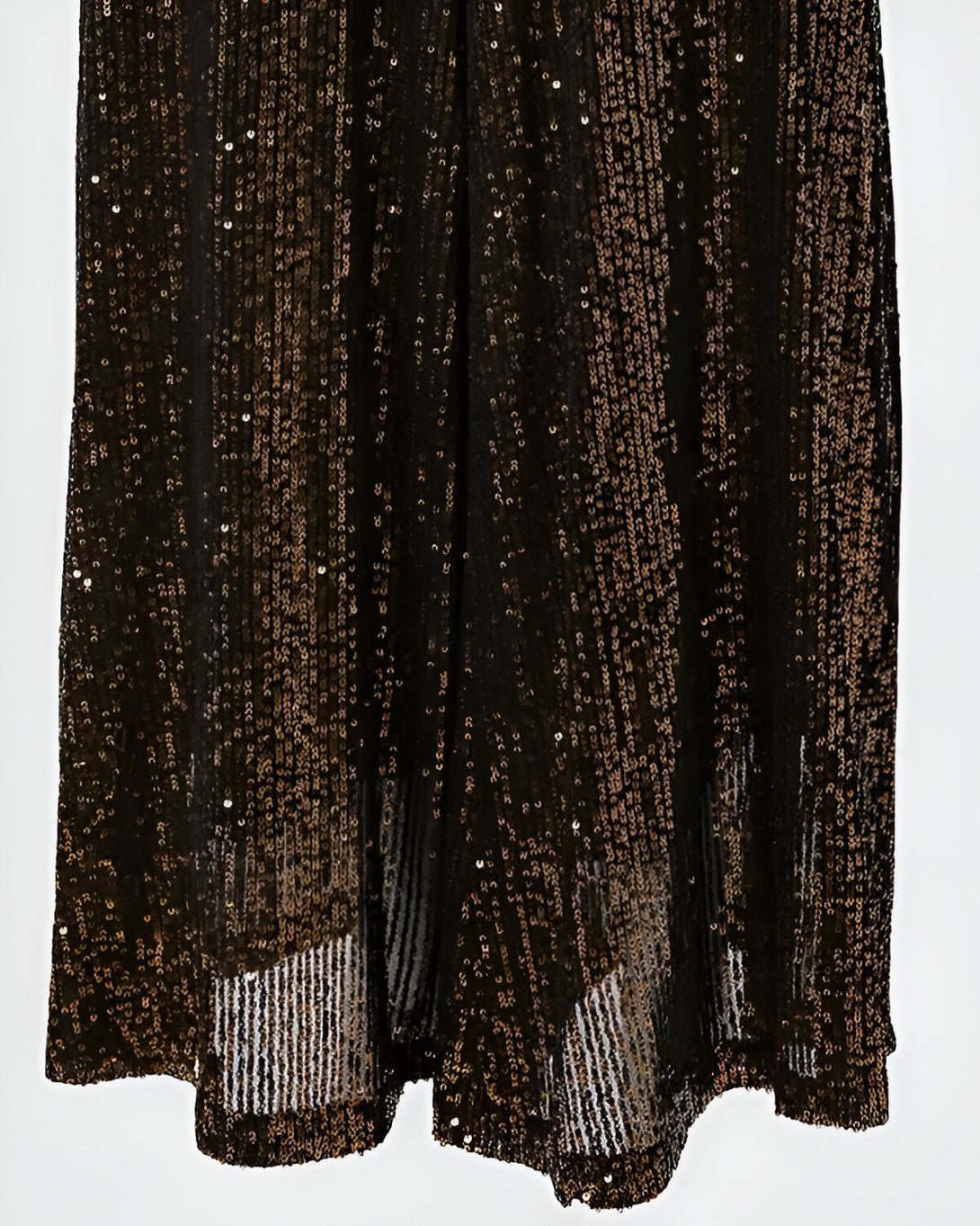 Une jupe longue noire à sequins bronze fendue sur le côté.