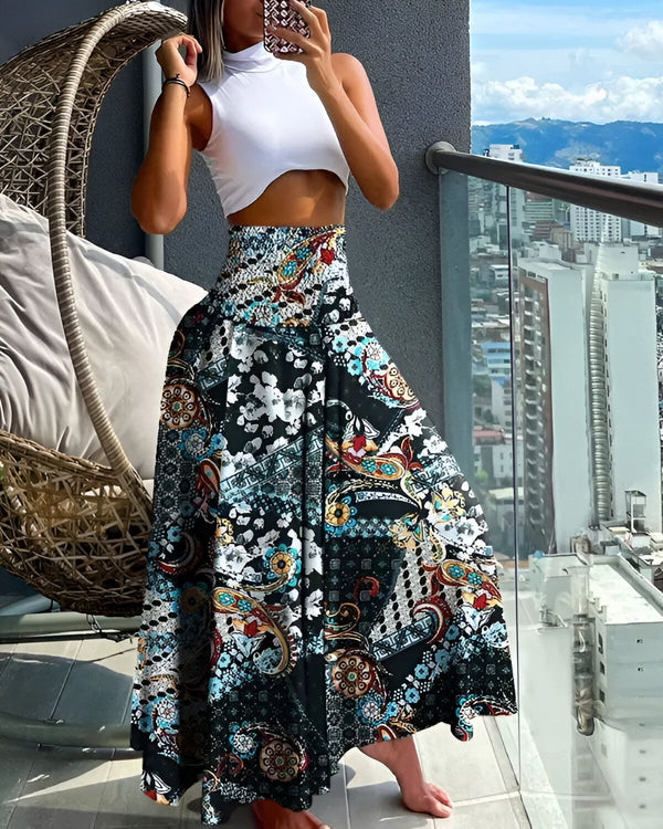 Une femme porte un pantalon taille haute large et coloré avec un haut blanc.
