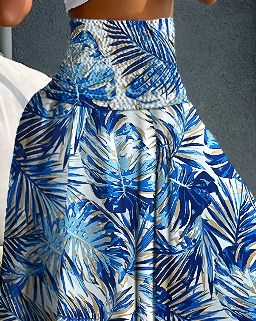 Une jupe longue et ample à taille haute, avec un motif de feuilles tropicales bleues et blanches.