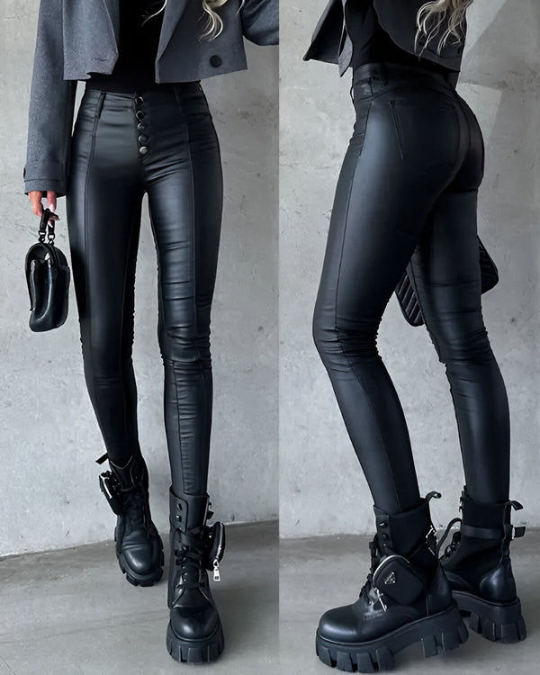 Une image d'une femme portant un pantalon en simili cuir noir et un blazer gris avec des boutons. Elle porte également des bottes noires à lacets.