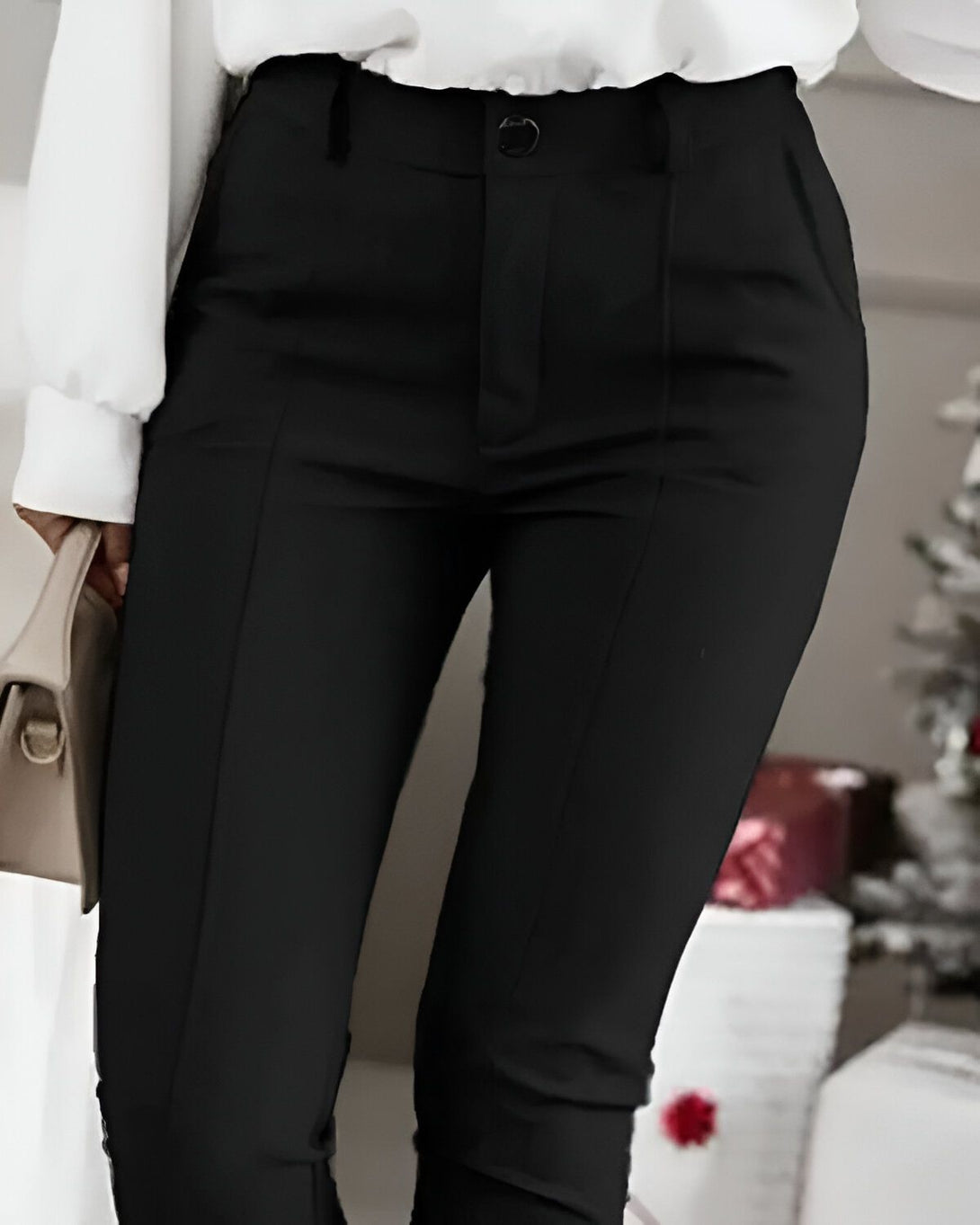 Une femme porte un pantalon noir moulant taille haute avec une chemise blanche et des talons hauts.