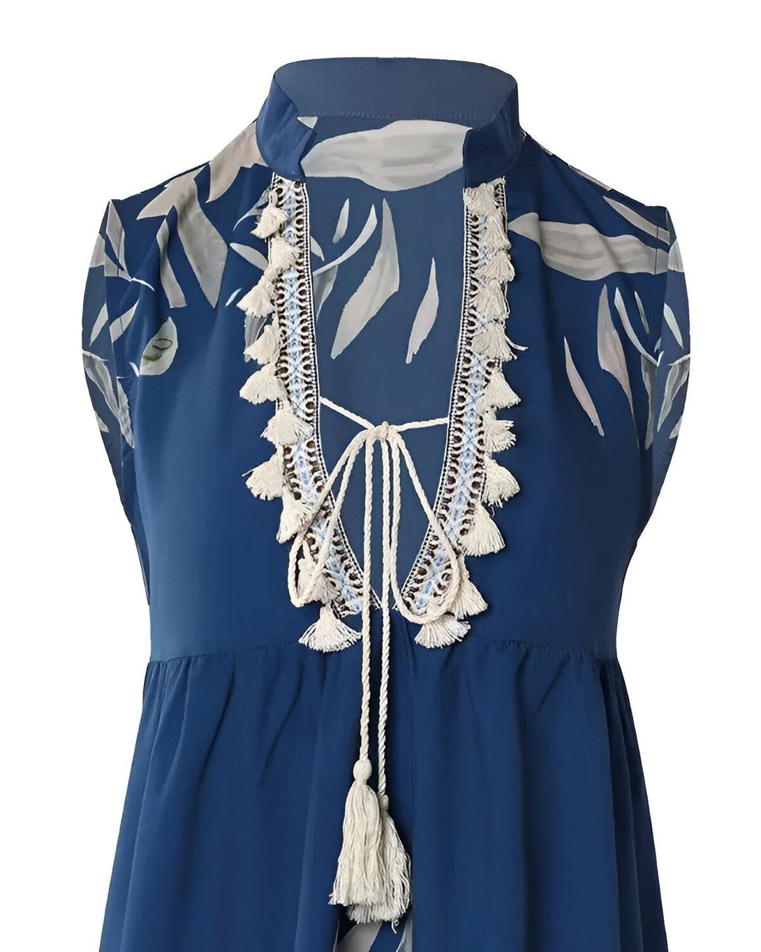Une image d'une blouse bleu marine à motifs de feuilles blanches et grises. La blouse a un col montant et des manches courtes. Elle est ouverte sur le devant et se noue avec un cordon.