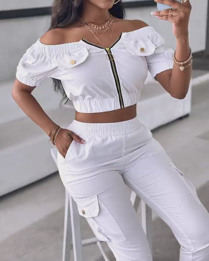 Video d'une femme portant : Ensemble haut à épaules dénudées et pantalon à revers avec fermeture éclair