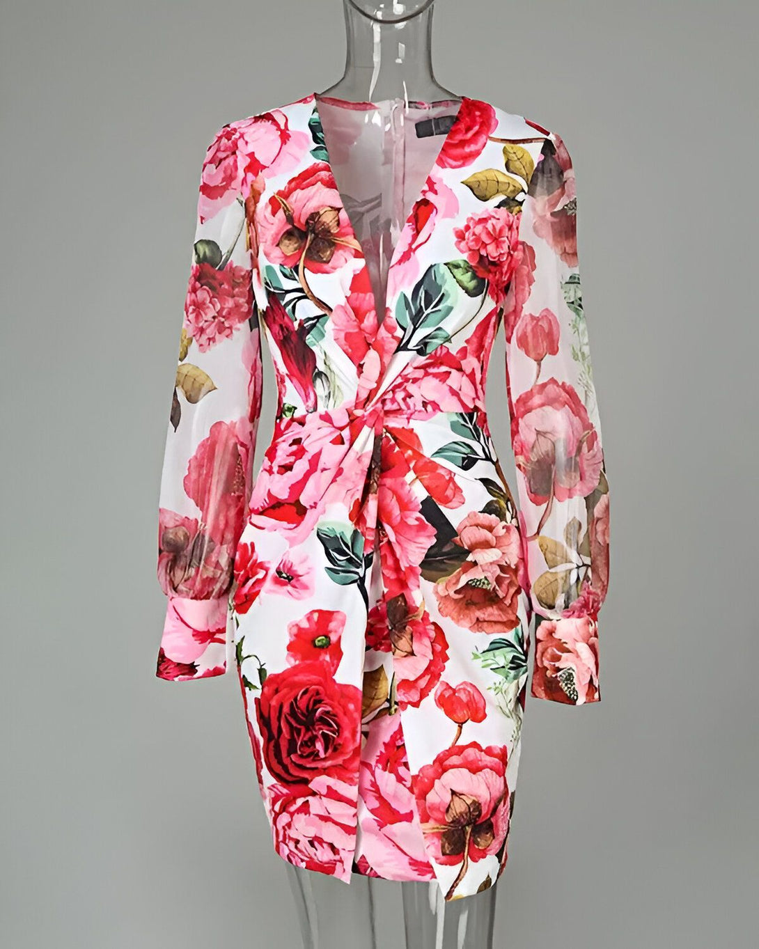 Une robe courte à manches longues avec un imprimé floral coloré. La robe est cintrée à la taille et possède un décolleté en V.