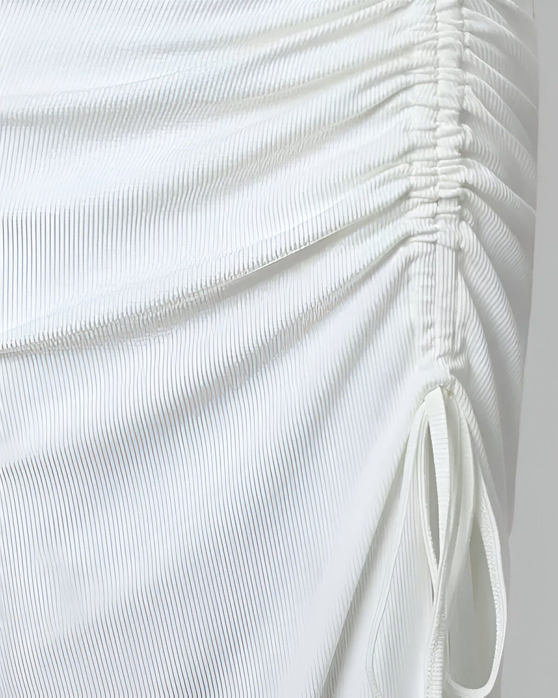 Une image d'une robe blanche en maille côtelée avec un lien à nouer sur le côté.