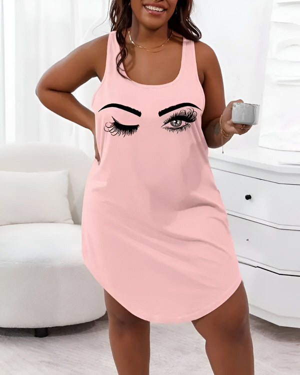 Une femme porte une nuisette rose avec un dessin d'un clin d'œil sur la poitrine. Elle est debout dans une chambre et tient une tasse à la main.