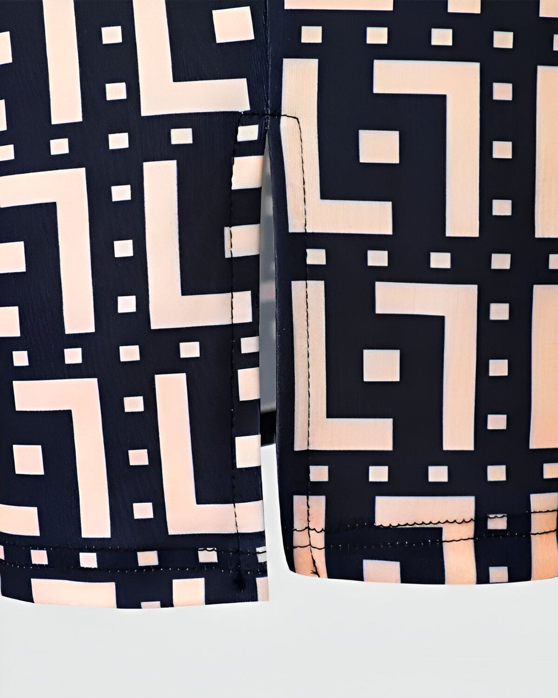Une image d'une robe noire et blanche à motifs géométriques. La robe est fendue sur le côté.