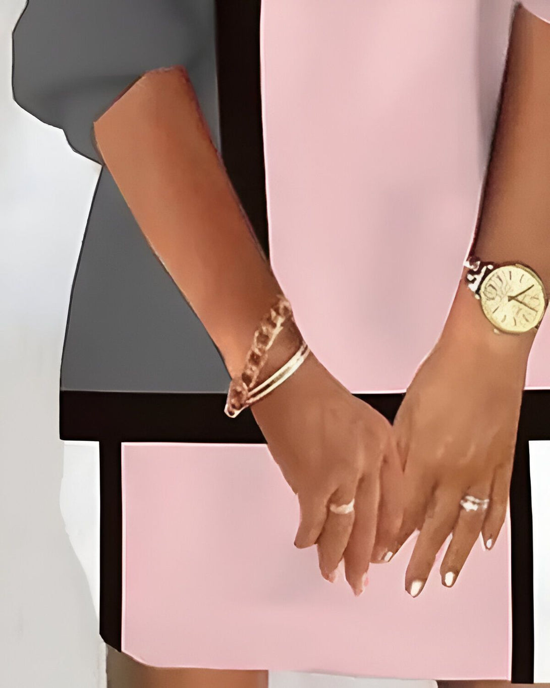 Une femme porte une montre-bracelet en or et un bracelet à chaîne doré. Elle porte également une bague en or à l'annulaire gauche et une bague en argent à l'index droit.