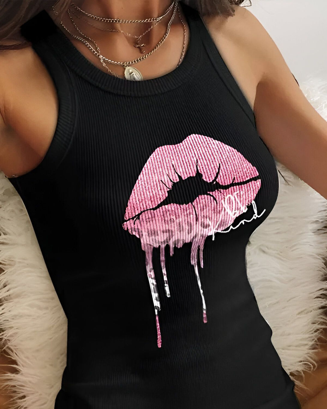 Une femme porte un débardeur noir avec un imprimé lèvres roses. Les lèvres ont un motif léopard et semblent dégouliner.