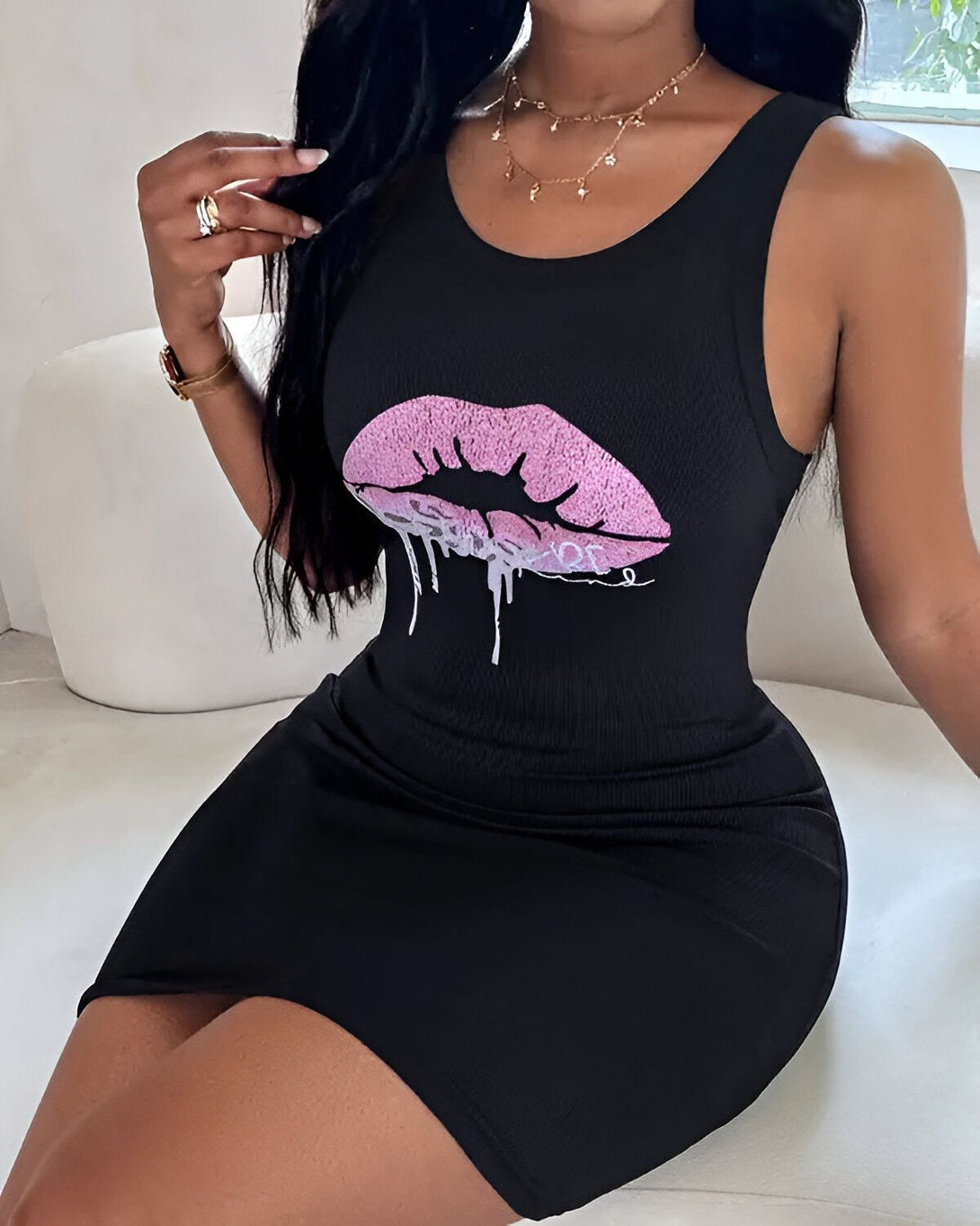 Une femme porte une robe noire moulante avec un imprimé lèvres roses.