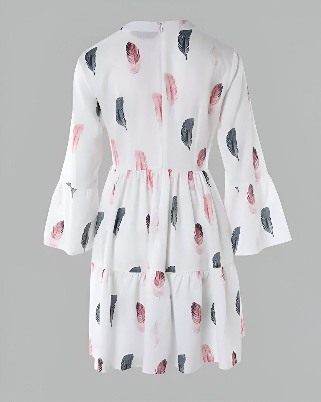 Une robe blanche à manches longues et à volants. La robe est imprimée de plumes roses et grises.