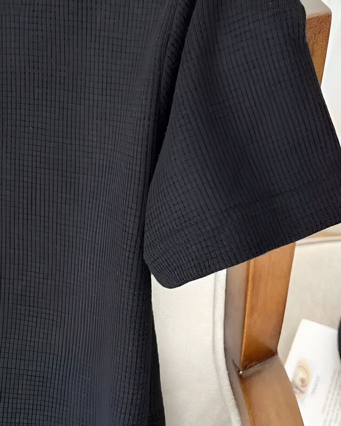 Une image d'une manche de chemise noire avec des plis.