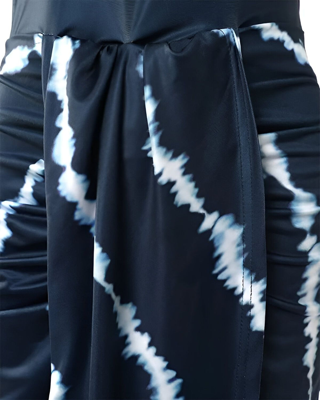 Une image d'une robe de soirée bleu marine et blanche. La robe est courte et ajustée, avec un décolleté en V et des bretelles fines. Elle est faite d'un tissu extensible et a une ceinture à nouer à la taille.