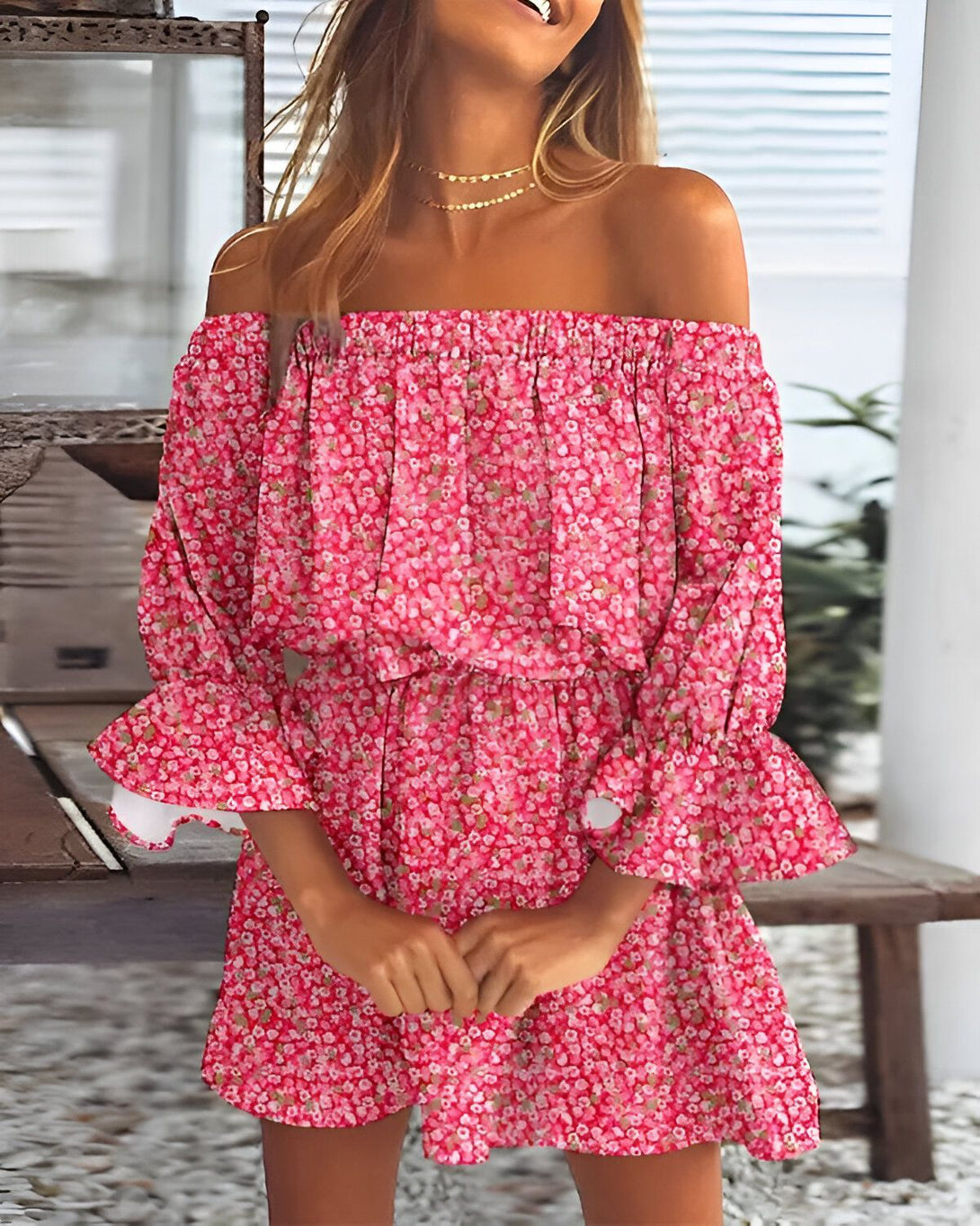 Une jeune femme portant une robe rose à fleurs et aux épaules dénudées.