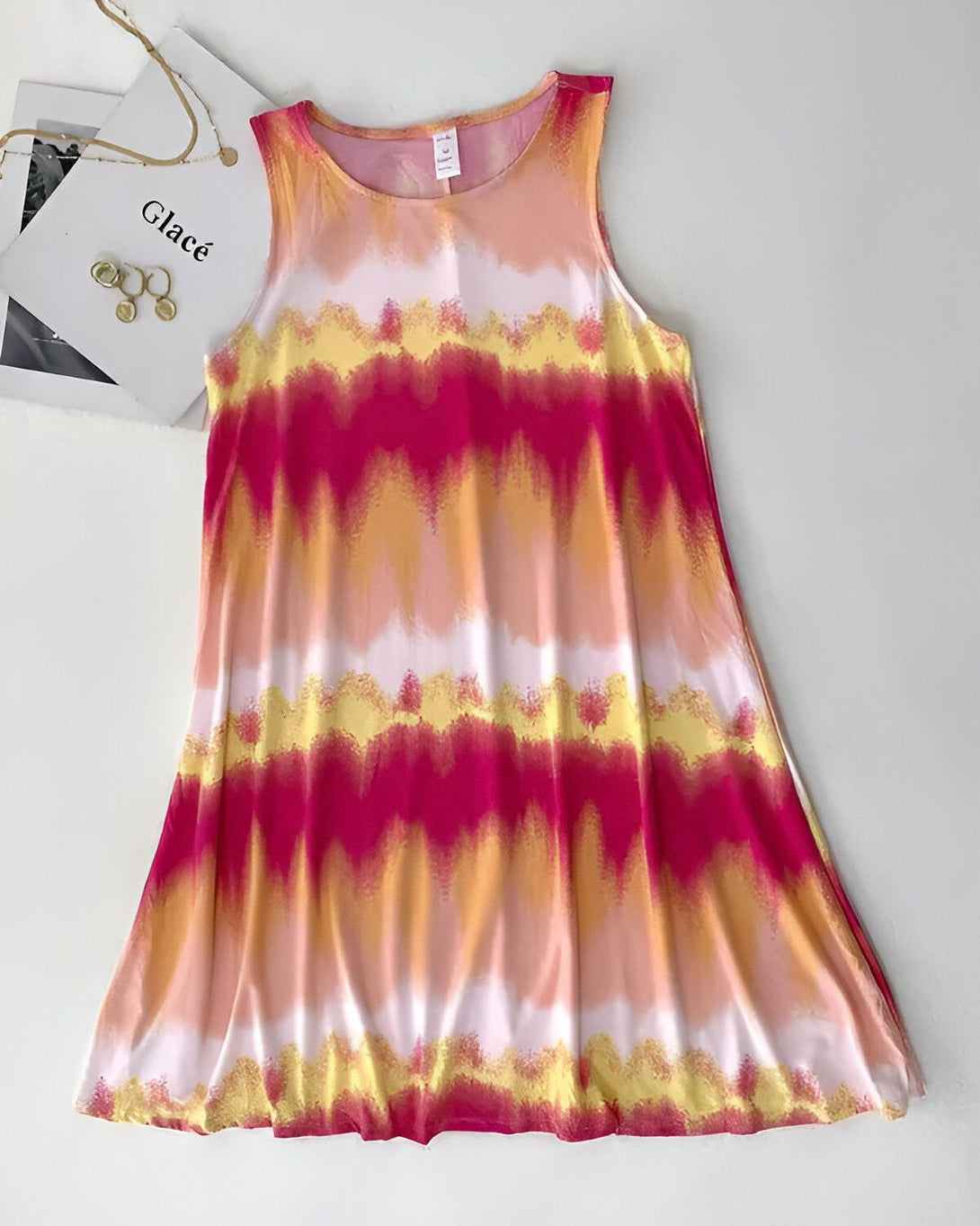 Une robe débardeur rose, jaune et blanche tie-dye.