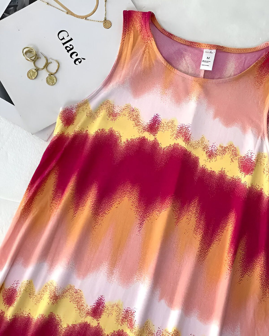 Une robe débardeur rose, orange et blanche tie-dye.