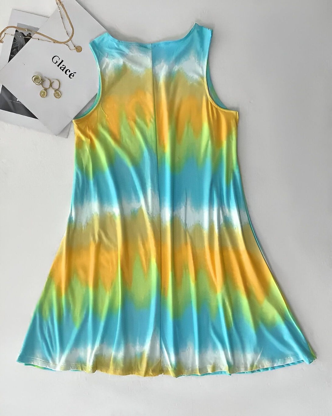 Une robe jaune, verte et bleue tie-dye sans manches avec un col rond et une jupe évasée.