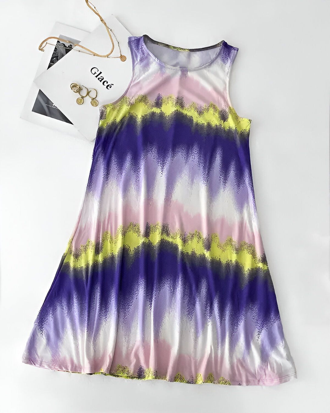Une robe débardeur évasée à motif tie-dye rose, jaune et violet.