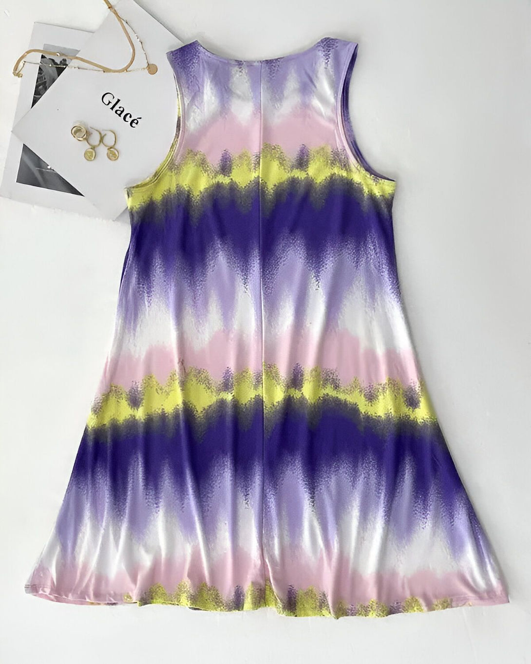 Une robe débardeur ample et évasée avec un motif tie-dye rose, jaune et violet.