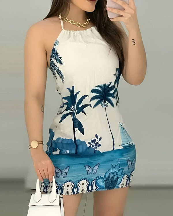 Une jeune femme porte une robe blanche avec un imprimé de feuilles de palmier bleues. La robe est courte et ajustée, et elle est nouée dans le cou. La femme porte également un collier doré et un bracelet doré. Elle tient un sac à main blanc dans sa main droite et prend un selfie avec son téléphone portable.