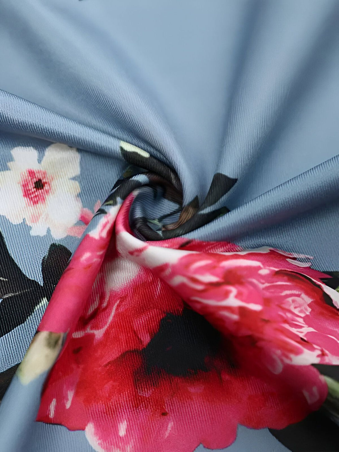 Une image de tissu bleu avec des fleurs roses et blanches.