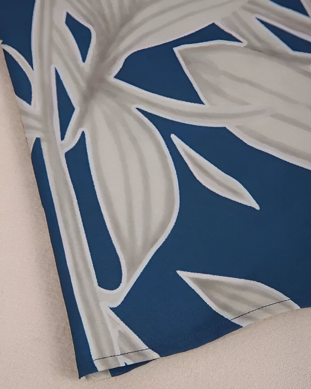Motif de feuilles tropicales sur fond bleu marine.