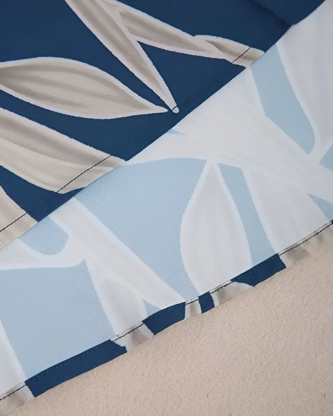Une image d'un tissu bleu marine à motifs de feuilles blanches et bleues.