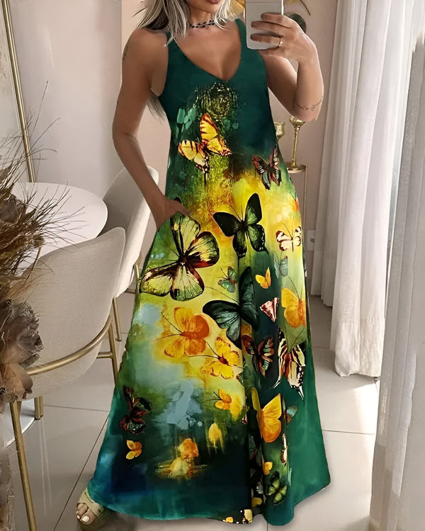 Une femme porte une robe longue verte à bretelles. La robe est imprimée de papillons multicolores. La femme est debout dans une pièce, elle a les cheveux longs et blonds.