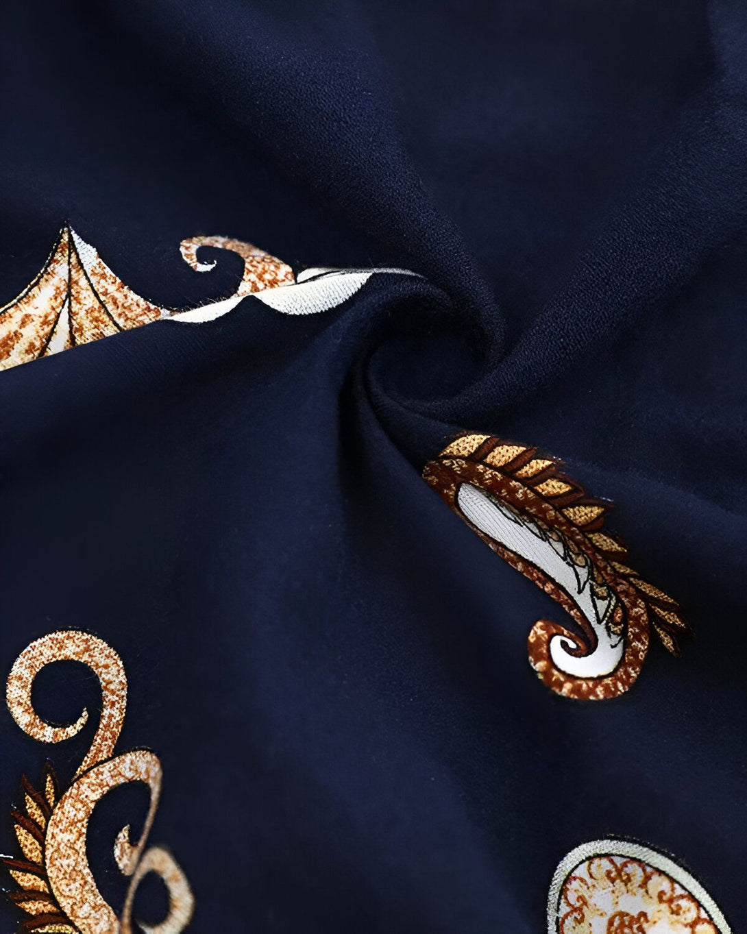 Une image d'un tissu bleu marine avec des motifs paisley dorés.