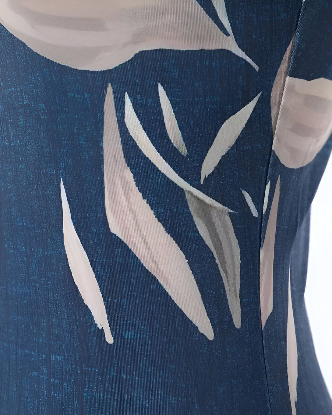 Une image d'un maillot de bain une pièce bleu avec des motifs de feuilles blanches et roses.