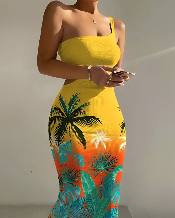 Une femme porte une robe jaune et blanche moulante à une épaule avec un imprimé de feuilles de palmier vertes et bleues.
