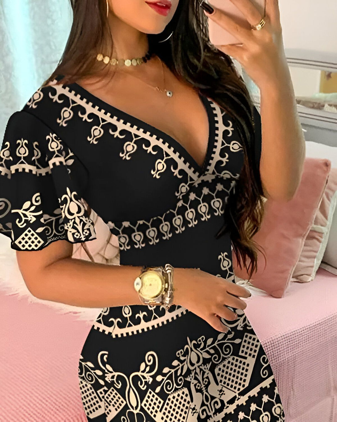 Une jeune femme porte une robe noire et beige décolletée à motifs baroques.