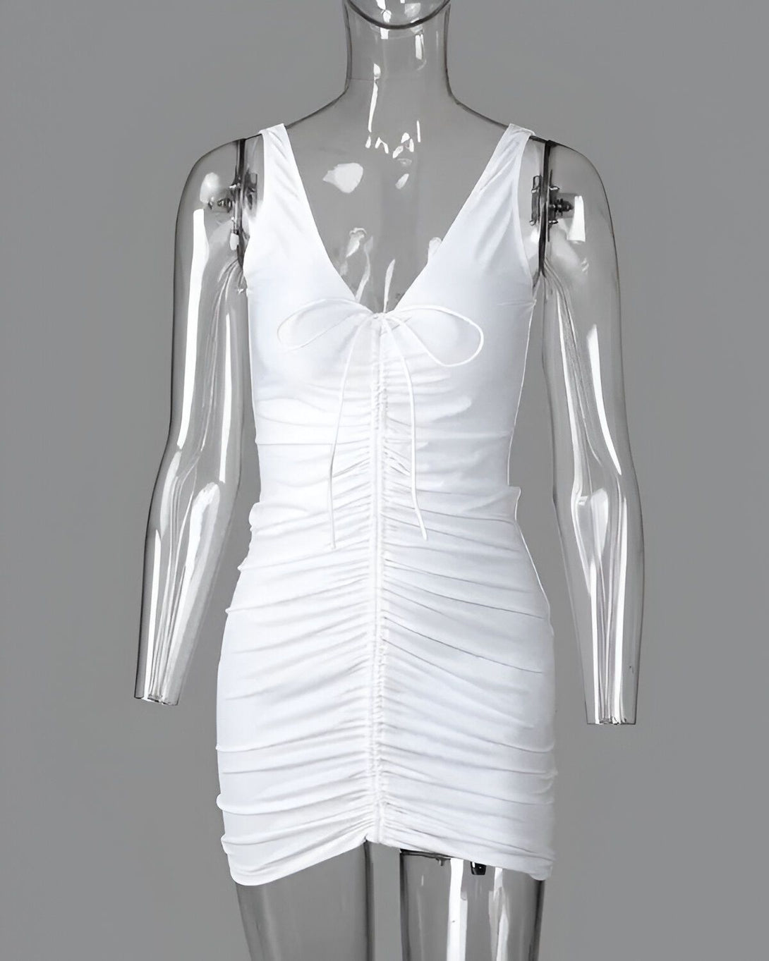 Une image d'une robe blanche moulante avec un décolleté en V et des bretelles fines. La robe est froncée sur le devant et est mi-longue.