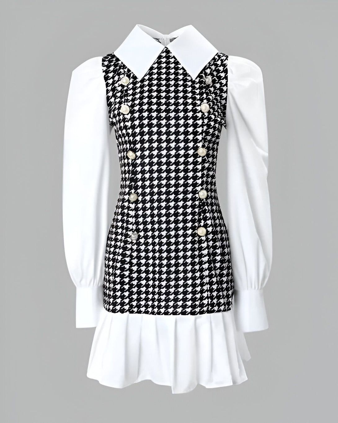 Une robe noire et blanche à motif pied-de-poule avec un col blanc et des manches bouffantes.