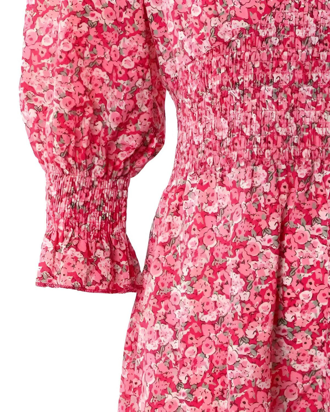 Une robe rose à fleurs avec des manches bouffantes et une taille froncée.