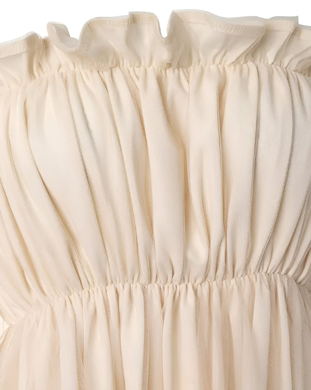 Une image d'une robe bustier en mousseline de soie ivoire. La robe est froncée sur la poitrine et a une jupe évasée.
