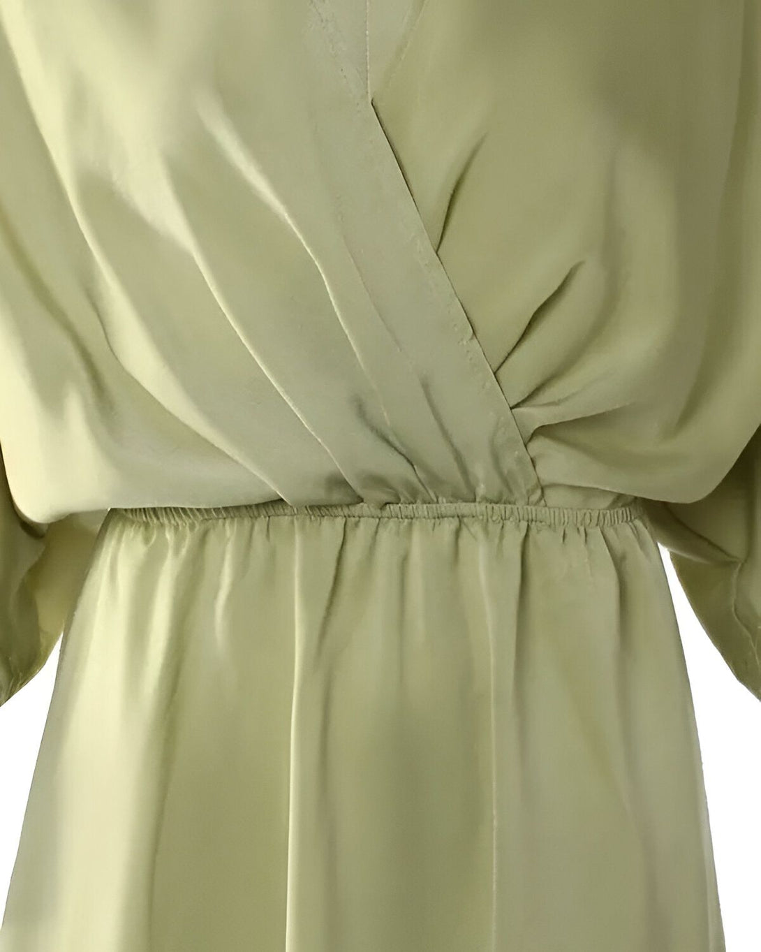 Une robe portefeuille en soie vert pâle avec des manches courtes et une taille froncée.