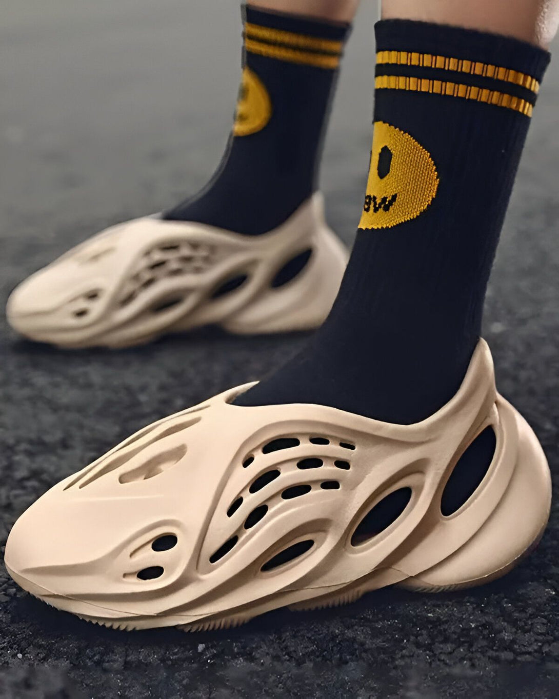 Une personne porte des chaussettes noires et des sandales beige trouées.