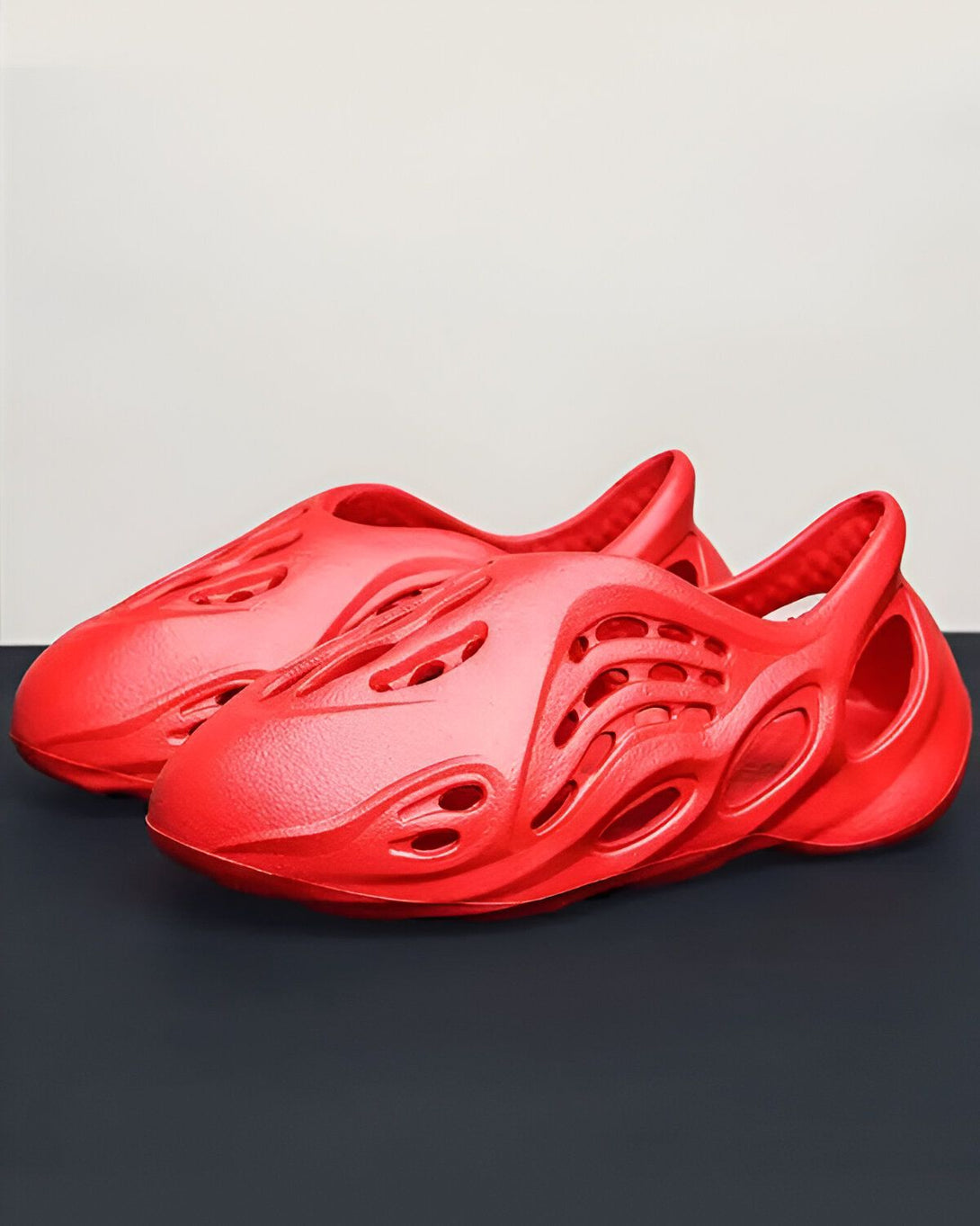 Une paire de sabots rouges en plastique avec des trous sur le dessus.
