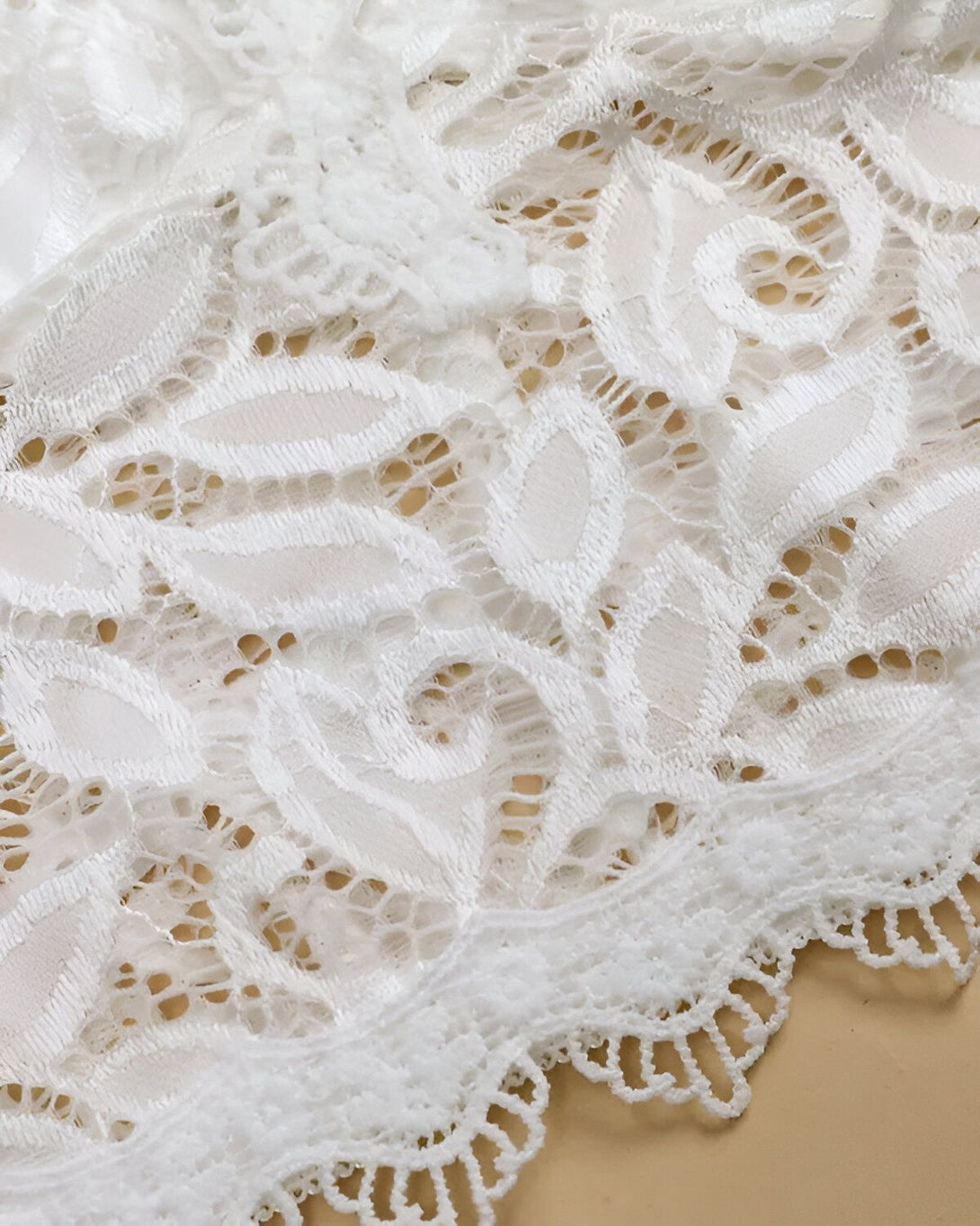 Dentelle blanche avec un motif floral.