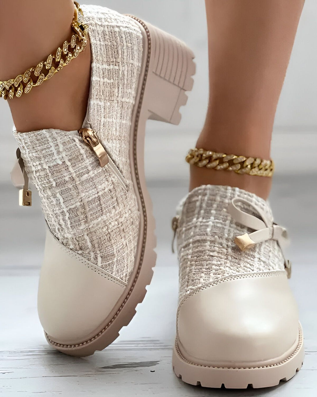 Une paire de bottes beiges à talons compensés avec un bout rond et une fermeture éclair sur le côté. Les bottes sont faites d'un tweed beige et marron et ont une semelle beige.